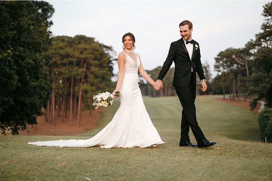 The bride and groom holding hands.