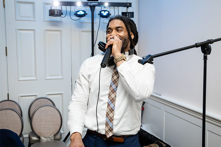 The DJ is speaking into a microphone.