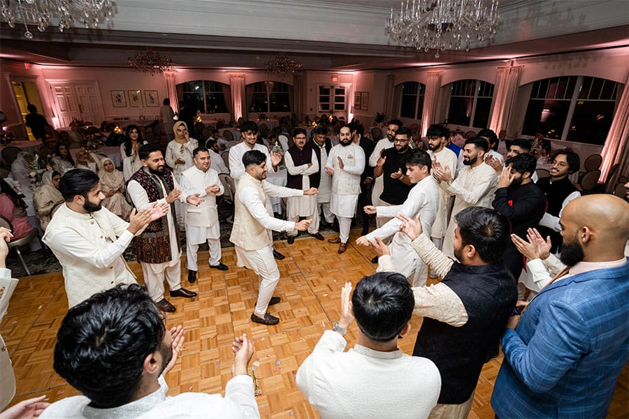 The friends and family of the bride and groom are dancing.