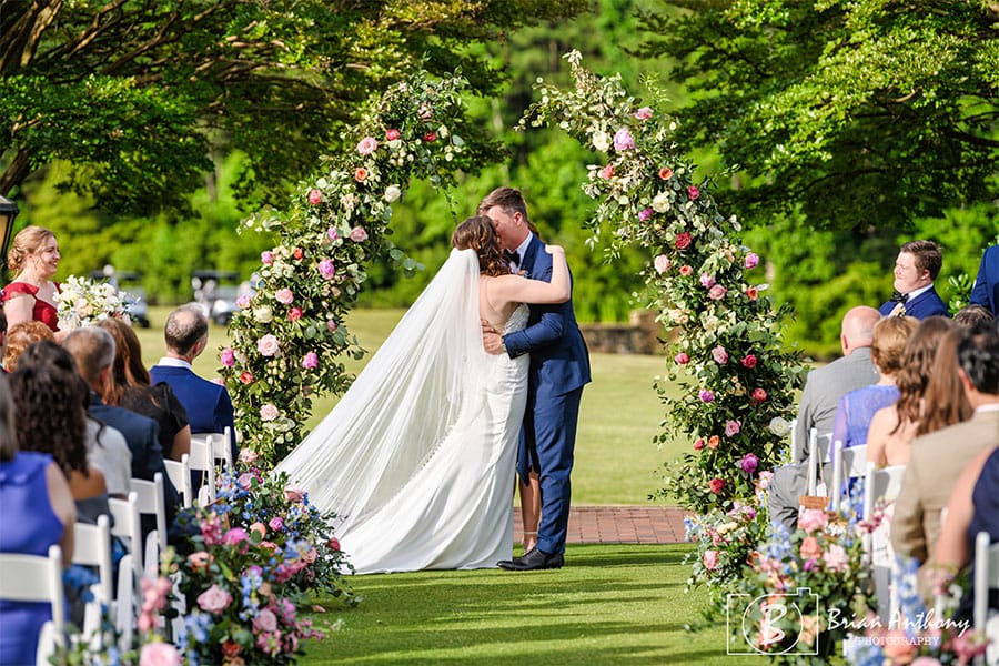 The bride and groom kissing at the alter.