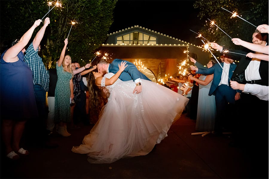 The bride and groom kissing with lights around them.
