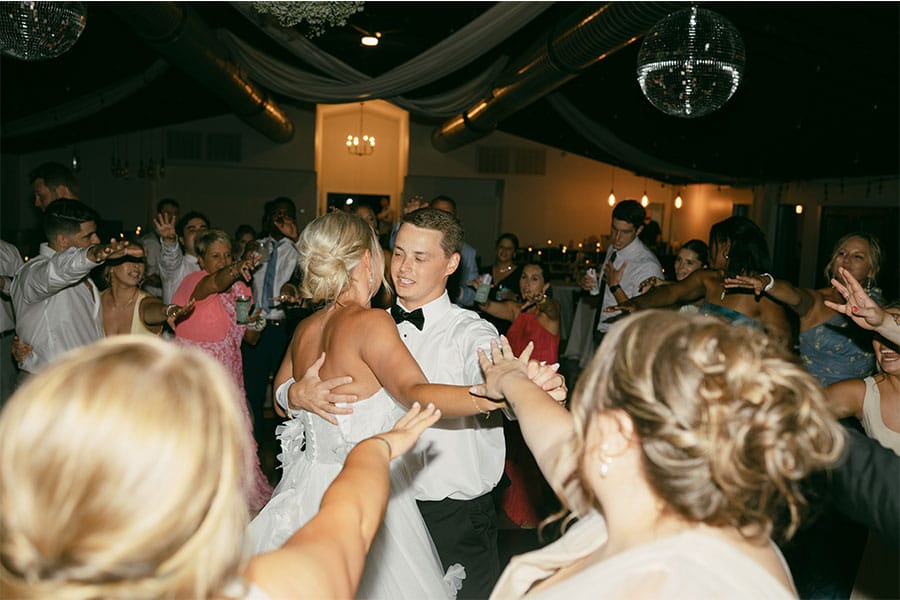 The bride and groom dancing with family and friends.