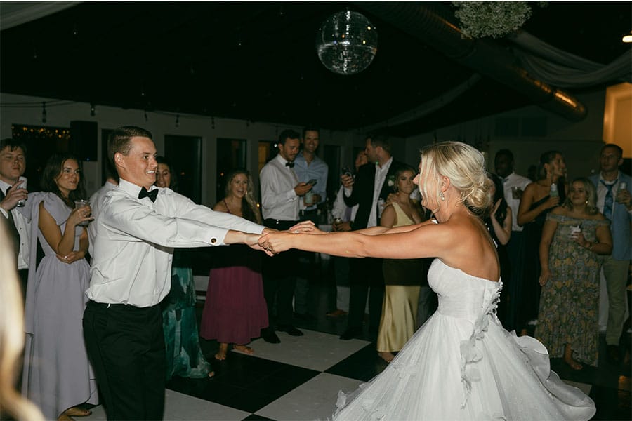 The bride and groom dancing with family and friends.