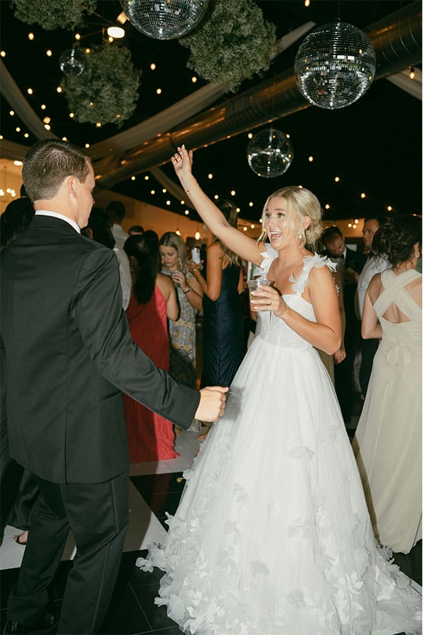 The bride and groom dancing with family and friends.