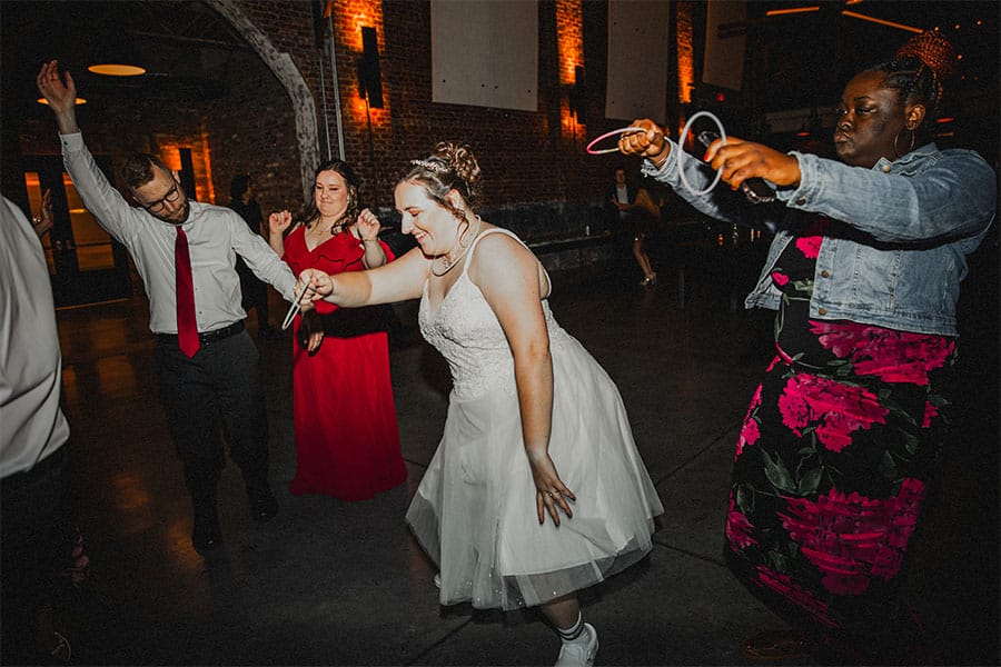 The bride and groom dancing with family and friends.