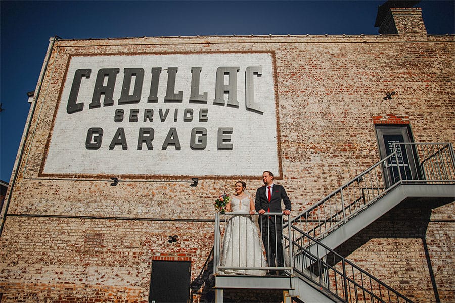 The bride and groom standing outside of their venue.
