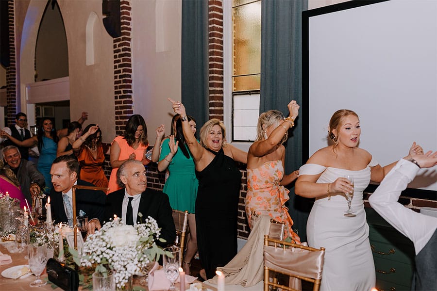 The couples family and friends dancing.