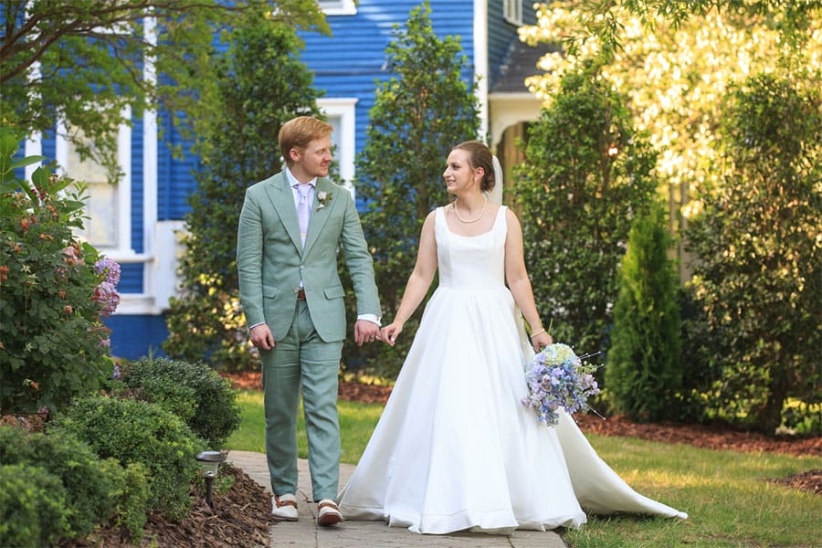 The bride and groom holding hands.