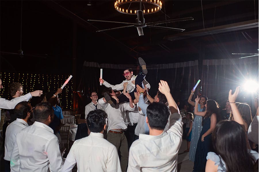 The bride and groom dancing with friends and family.