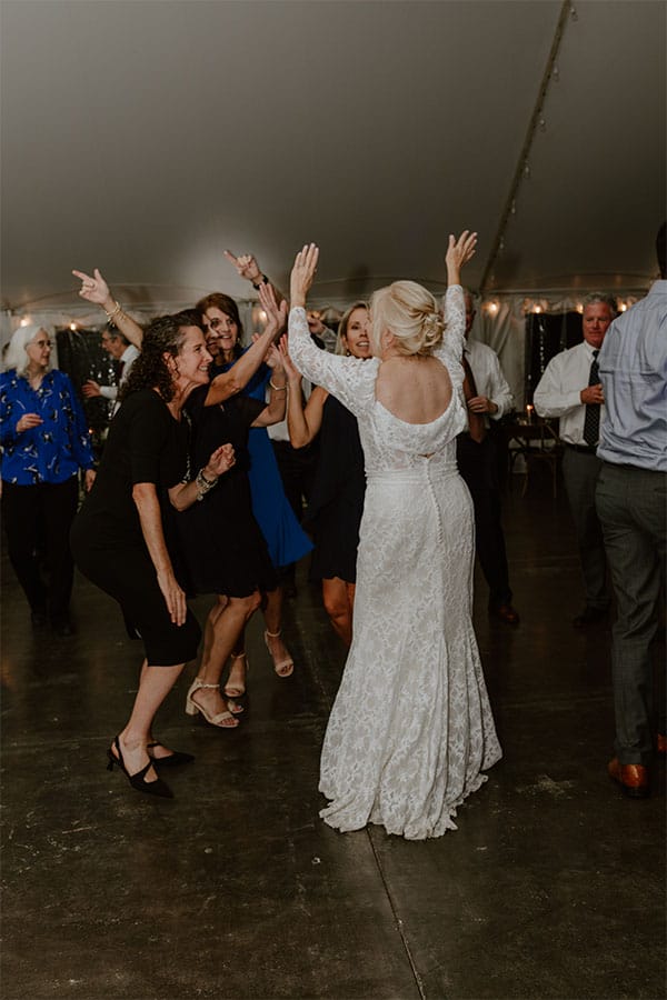 The bride dancing with friends and family.