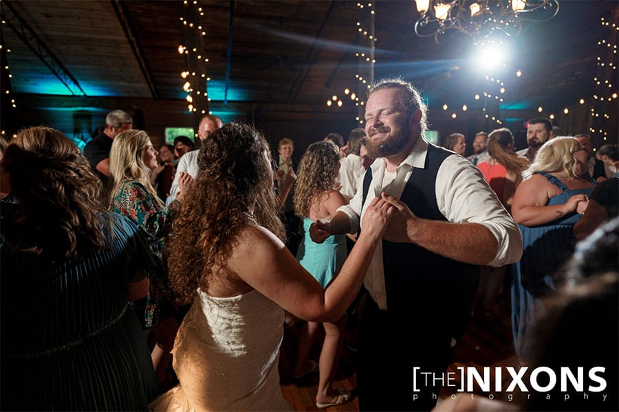 The bride and groom dancing with friends and family.
