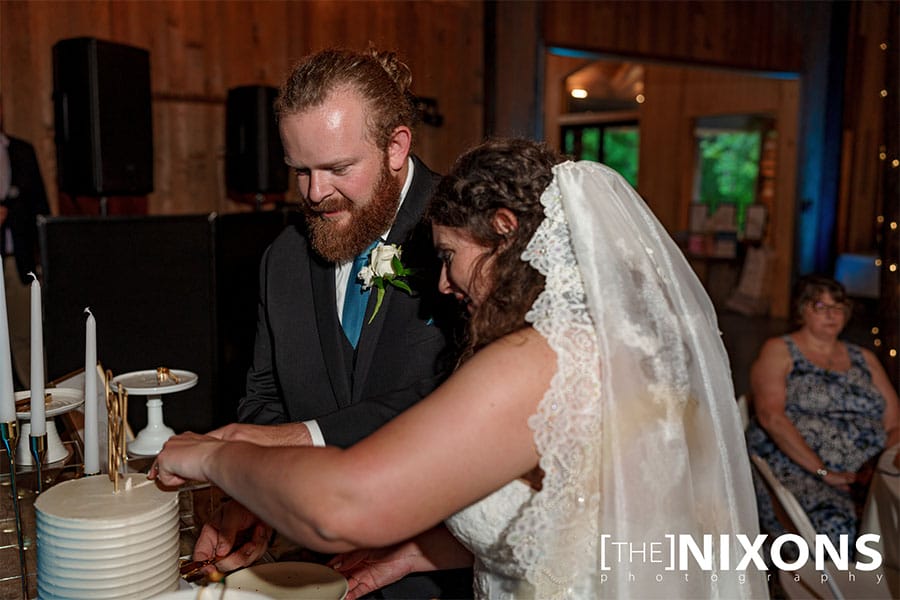 The bride and groom cutting their wedding cake.