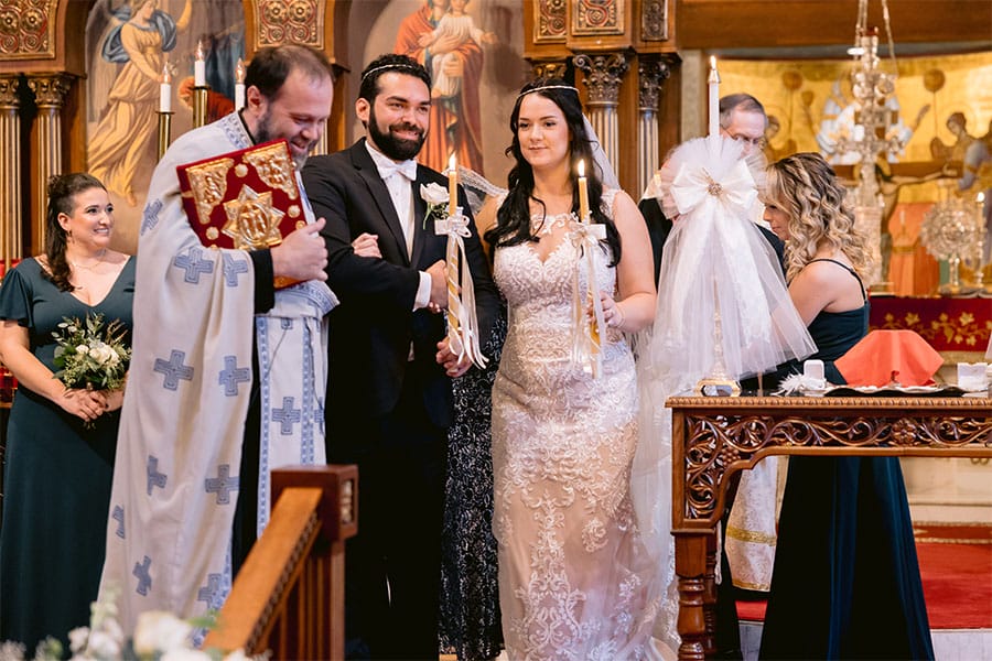 The bride and groom holding candles.